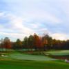 A fall view of a green flanked by sand traps and a pond at Thundering Waters Golf Club